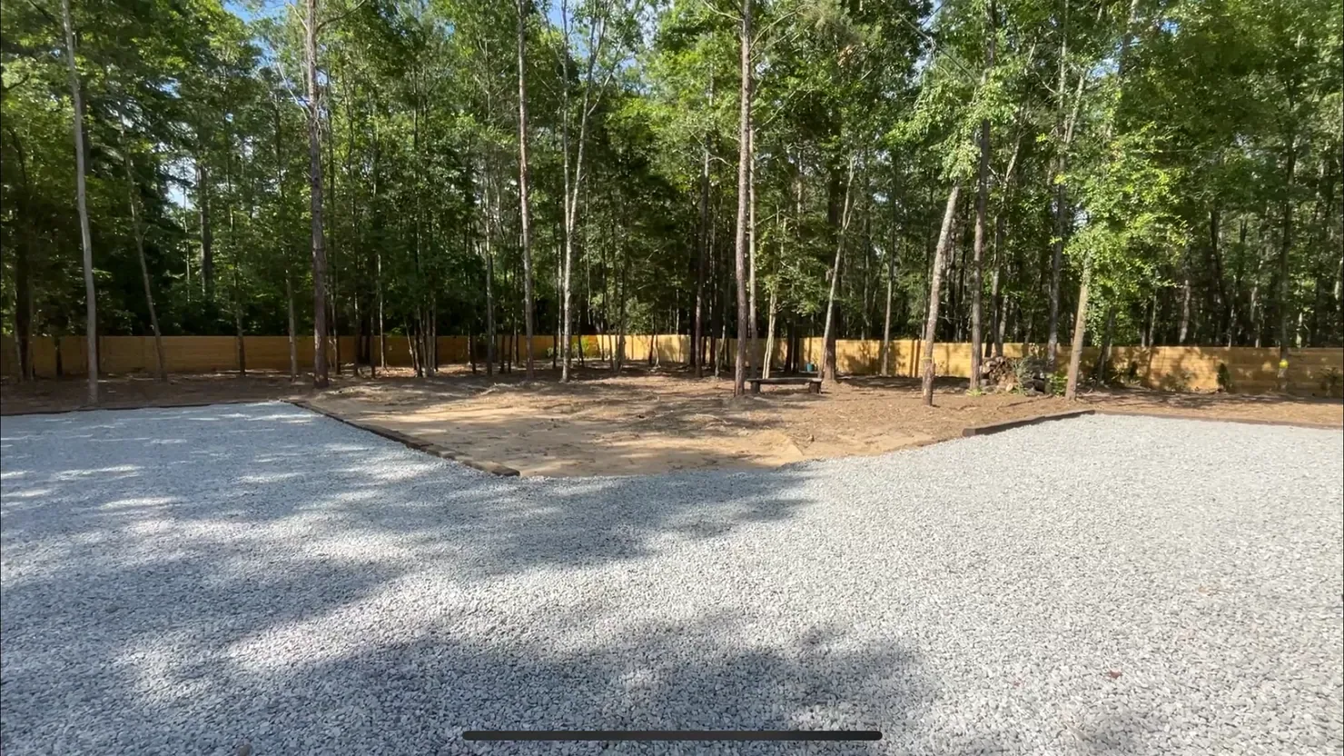Finished graded yard beneath mature shade trees